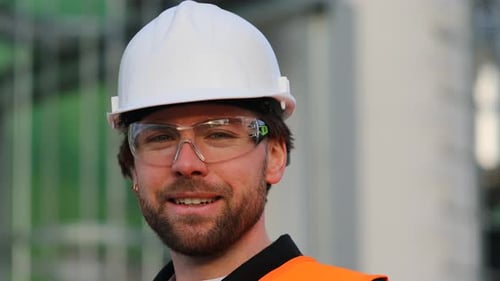 Smiling Construction Worker in Hard Hat and Safety Glasses