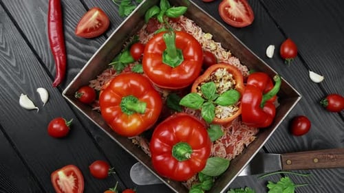 Gefüllte rote Paprika mit Reiszwiebeln auf schwarzem Steinhintergrund