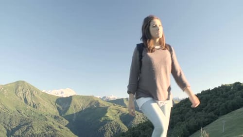 Front View of Young Woman Hiking Toward Camera in Mountain Outdoor Nature Scenery During Sunny