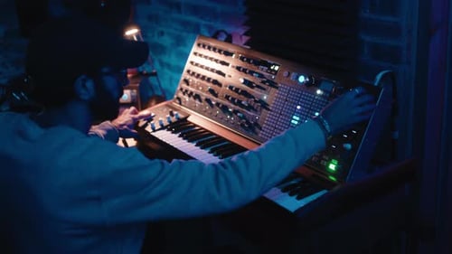 Musician Composing on Synthesizer Keyboard in Studio