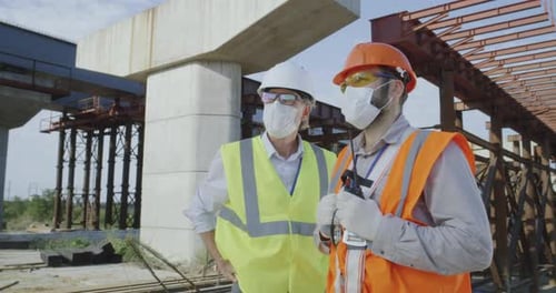 Construction Workers Discussing Progress at a Bridge Site