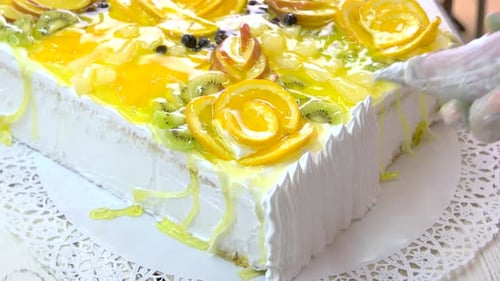 Delicious Cake being Decorated with Fruit and Cream