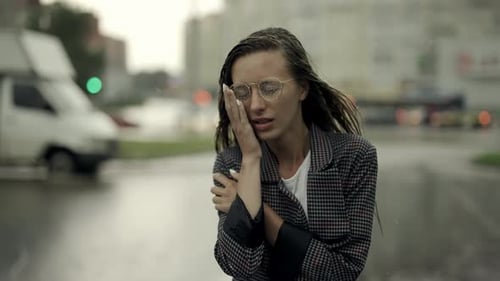 Young Businesswoman is Walking in the City While It is Raining