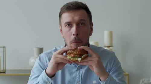 Man Bites Into Hamburger Close Up Shot