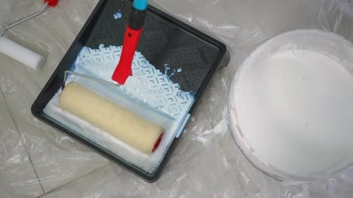 High Angle View Dipping Paint Roller in White Paint Indoors