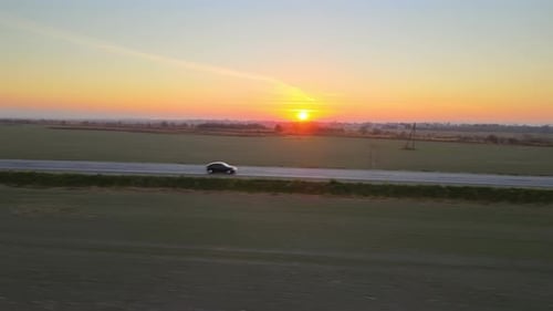 Luftaufnahme der Intercity Road mit schnell fahrendem Auto bei Sonnenuntergang