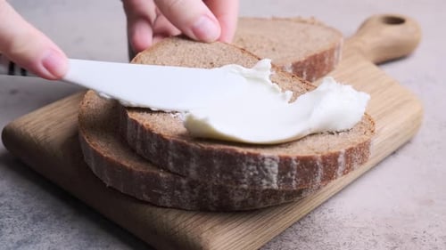 Cream Cheese Spreading on Rye Bread Slice