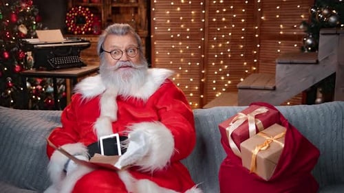 Santa Claus Reading Christmas Wish List at Illuminated Garland