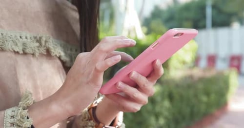 Woman Uses Smartphone Outside on Sunny Day