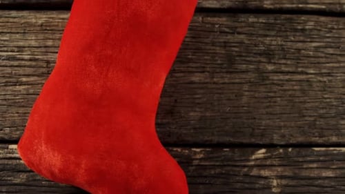 Red Christmas Stocking on Rustic Wood Background
