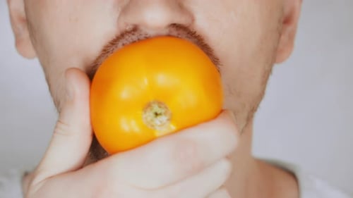 Close Up Face Fair Man Eats Tomato