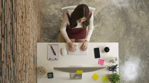 Top view of smiling Asian business woman, person working from home, typing on a keyboard