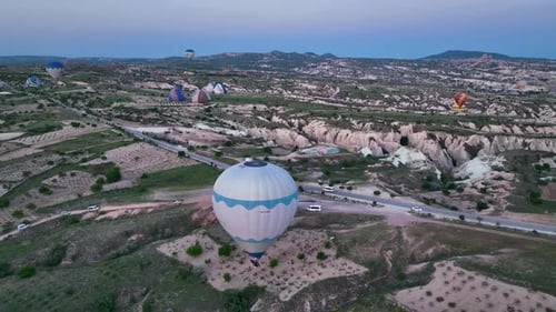 4K Aerial view of Goreme. Colorful hot air balloons fly over the valleys.