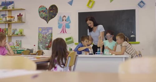 Elementary School Science Classroom Enthusiastic Teacher Explains Chemistry to Diverse Group of