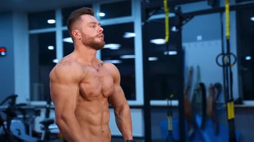 Muscular Man Posing Shirtless in Gym