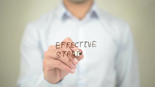 Man Writes Effective Strategy on Clear Surface