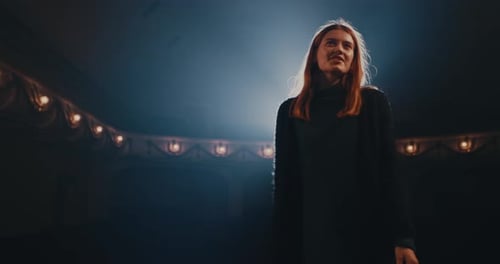 Woman Performing on Stage in Theater Spotlight