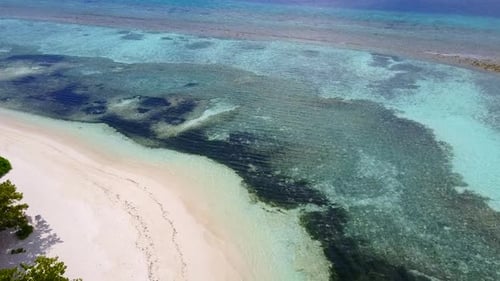 Daytime texture of coastline beach by ocean and sand background near waves