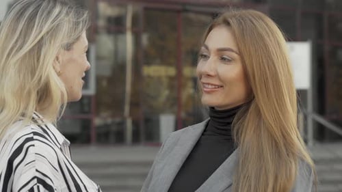 Zwei Kolleginnen unterhalten sich freudig im Freien