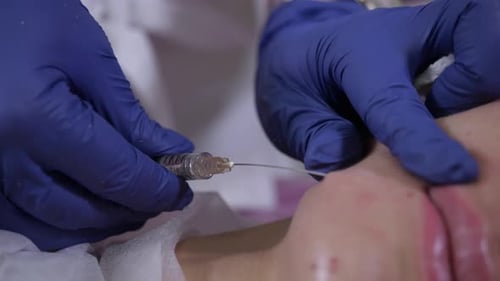 Der Doktor der Kosmetikerin führt einen kosmetischen Eingriff mit einer Spritze durch