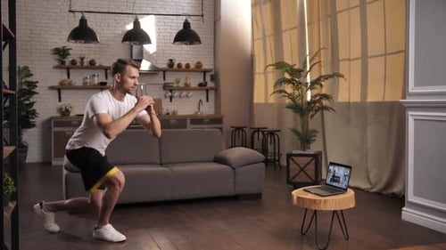 Man Doing Lunges with Resistance Band at Home