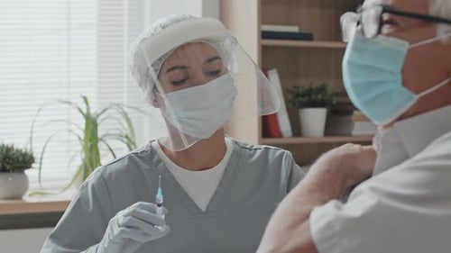 Doctor Gives Senior Adult Vaccination in Office