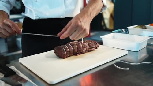 Close-up: The chef cuts the meat of the filet mignon with a knife. The process of preparing food