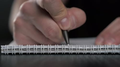Close Up Super Macro Shot of a Man Hand Writing Something on the Paper Notebook Pencil