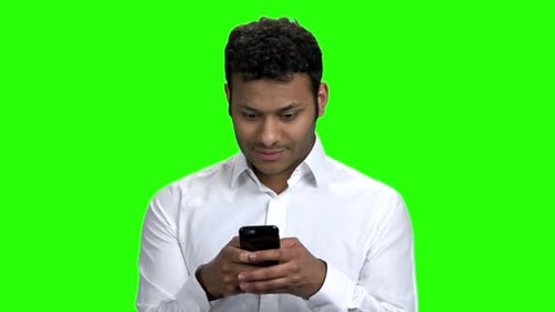 Smiling Businessman Typing Message on His Phone