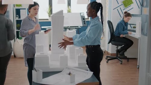 Women Analyzing Building Model Using Maquette and Tablet for Development