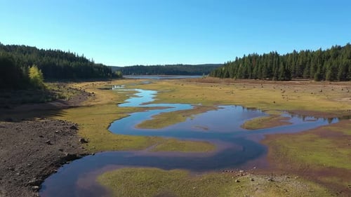 Drone aérien survolant un lac asséché à cause des étés chauds qui provoquent la sécheresse.