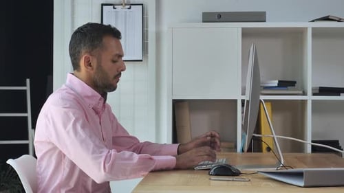 Man Works at Computer in Office