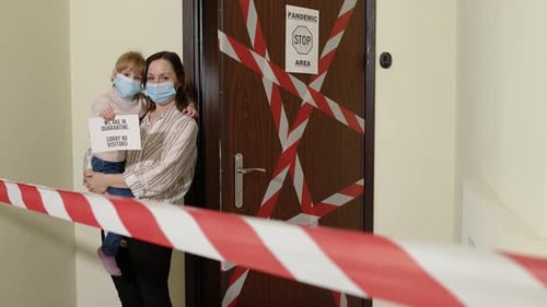 Woman and Child Behind Quarantine Tape with Sign