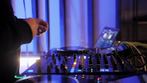 Close Up Dj Hands Disc Jockey Mixing Music on His Deck with His Hands Poised Over the Vinyl Record