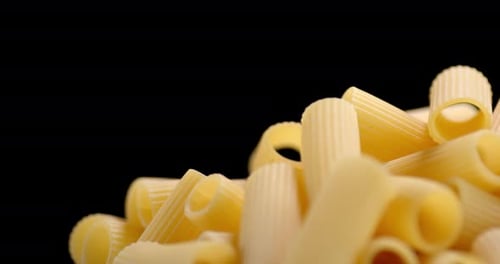 Close Up of Uncooked Rigatoni Pasta on Black