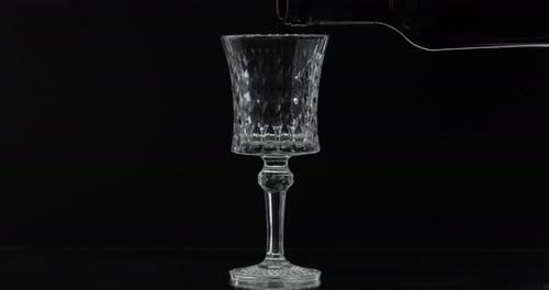 Wine Pouring into Crystal Glass on Black