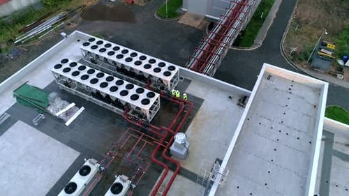 Engineers Inspecting Industrial Equipment on Rooftop Aerial Shot