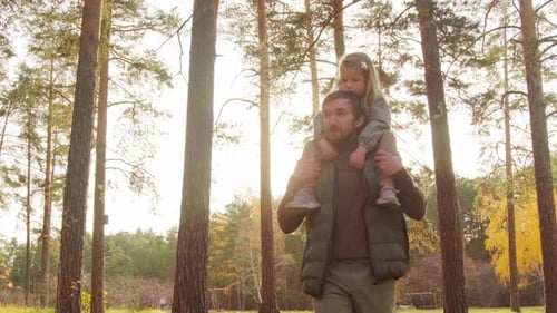Father and Daughter Walking through Forest
