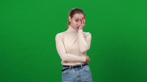 Porträt einer jungen schockierten Frau, die Gesicht hält und die Hand in die Kamera schaut