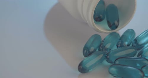 Capsules and Bottle on White Surface