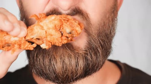 Bearded Man Eating Fried Chicken Wing Close Up