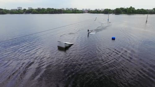 Handsome Guy in a Wetsuit Is Riding a Wakeboard on the River