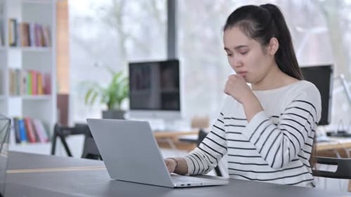 Woman Coughing While Working at Her Laptop