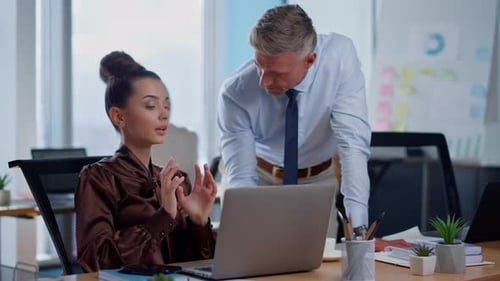 Serious Businessman and Businesswoman Discussing Ideas in Office