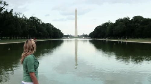 Young woman by reflecting pool and washington monument