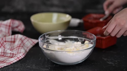Hands Mixing Dough Ingredients in Glass Bowl