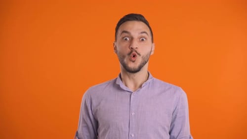 Man Expressing Shock and Excitement on Orange Background