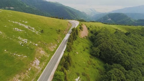 Top View of A Car Making a Turn on A Road Situated on A Steep Mountain Hill