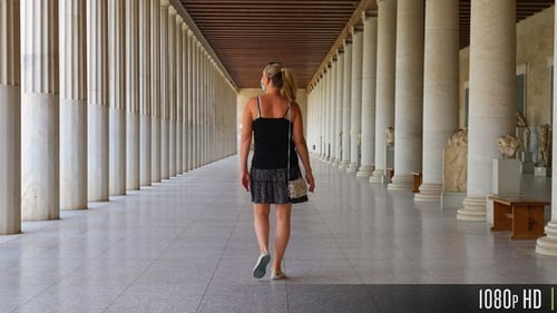 Después de un paseo turístico por un largo pasillo de columnas griegas en Stoa of Attalos, Atenas, Grecia