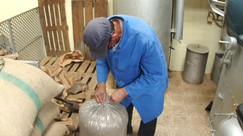 Trabajador masculino atando una bolsa de cáscaras de café